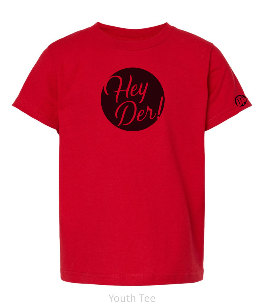 black circle with "Hey Der!" in modern script on red youth t-shirt, "Little UP" in circle small on sleeve