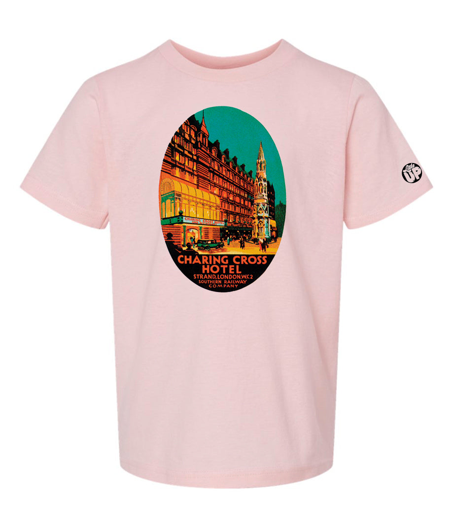 oval illustration of old hotel in London, colors include orange, teal green, yellow and black, printed on pink youth t-shirt on white background