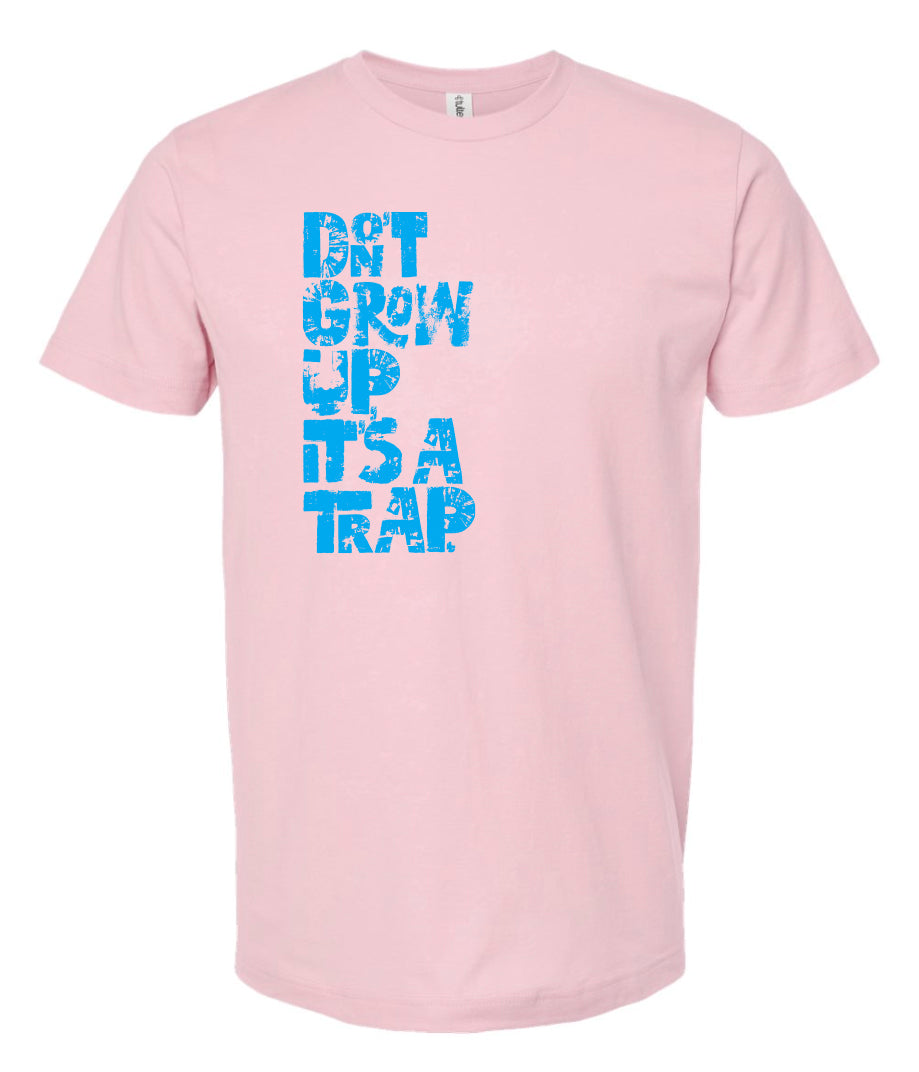 "DON'T GROW UP, IT'S A TRAP" in light blue in fun, textured font on pink t-shirt