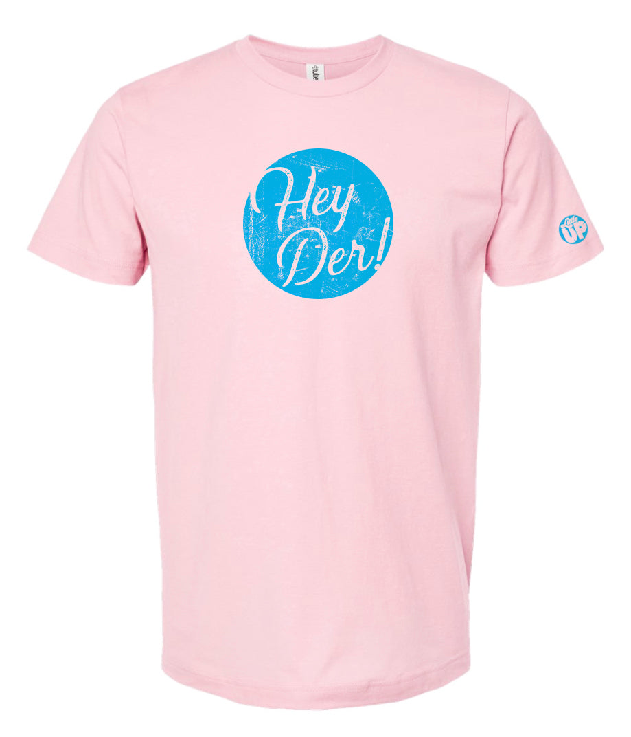 "Hey Der!" in script font, white on textured light blue circle, on pink t-shirt on white background