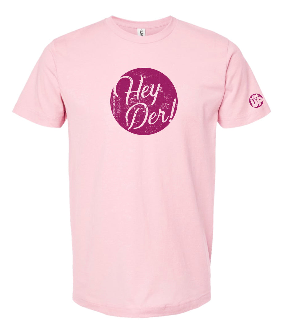 "Hey Der!" in script font, white on textured purple circle, on pink t-shirt on white background