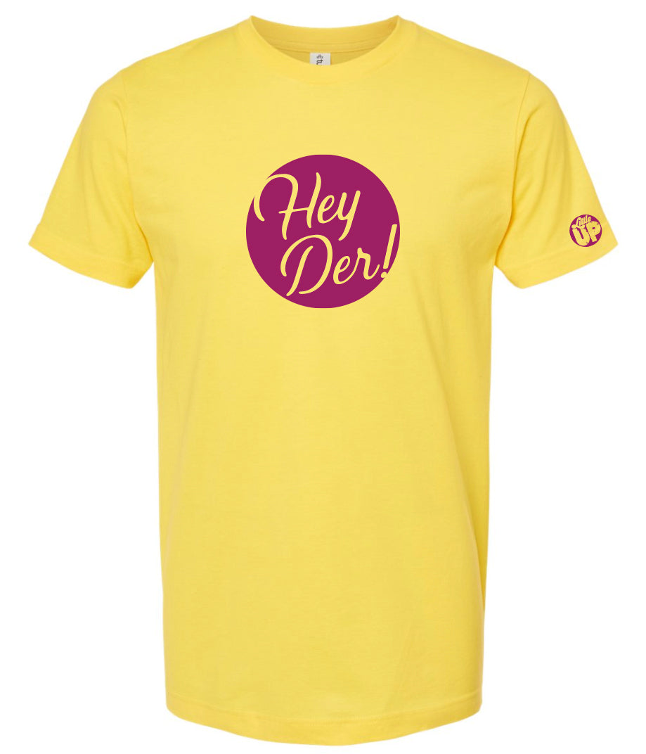 "Hey Der!" in script font, white on purple circle, on yellow t-shirt on white background