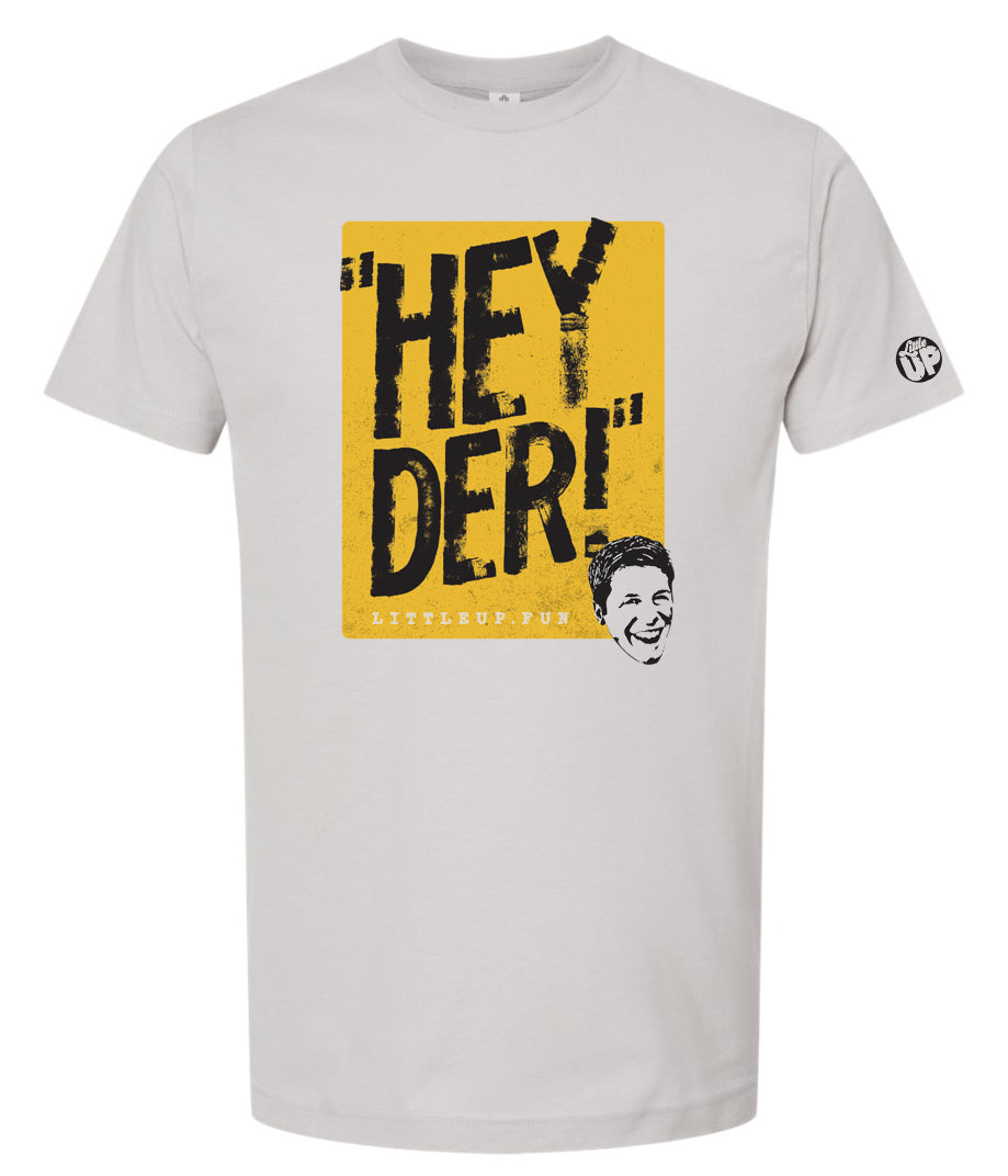 "HEY DER!" large in black on yellow box with young man with big smile in the lower right corner on silver t-shirt