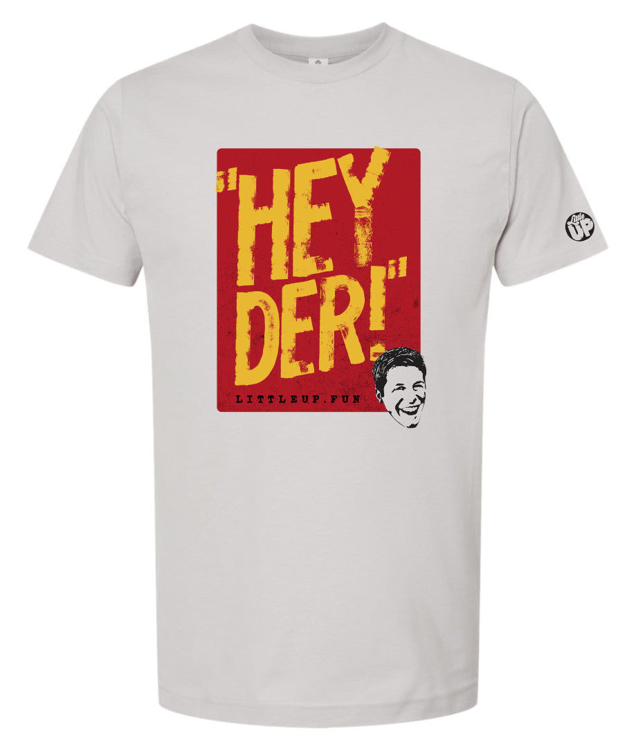 "HEY DER!" large in yellow in red box with young man with big smile in the lower right corner on silver t-shirt