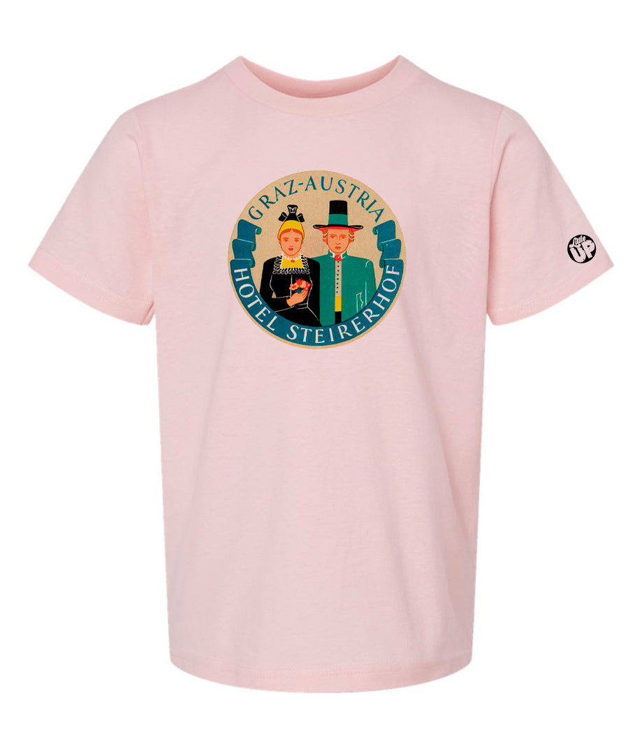vintage round illustration of old hotel in Austria, colors include blue, orange, teal, yellow and black, printed on pink youth t-shirt on white background