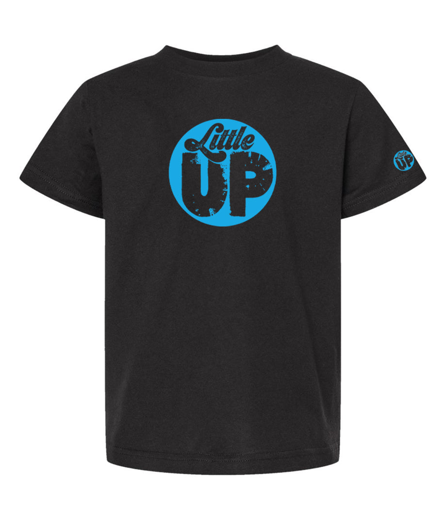 light blue circle logo with "Little" in the top third in textured seventies script and "UP" on the bottom ⅔ in modern sans serif textured font on black youth t-shirt on white studio background