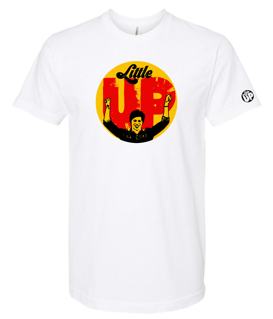 large circle with "Little" at the top in 70s script, "UP" large in red textured sans serif, illustration of young man smiling with arms raised illustration in black at the bottom, on white t-shirt