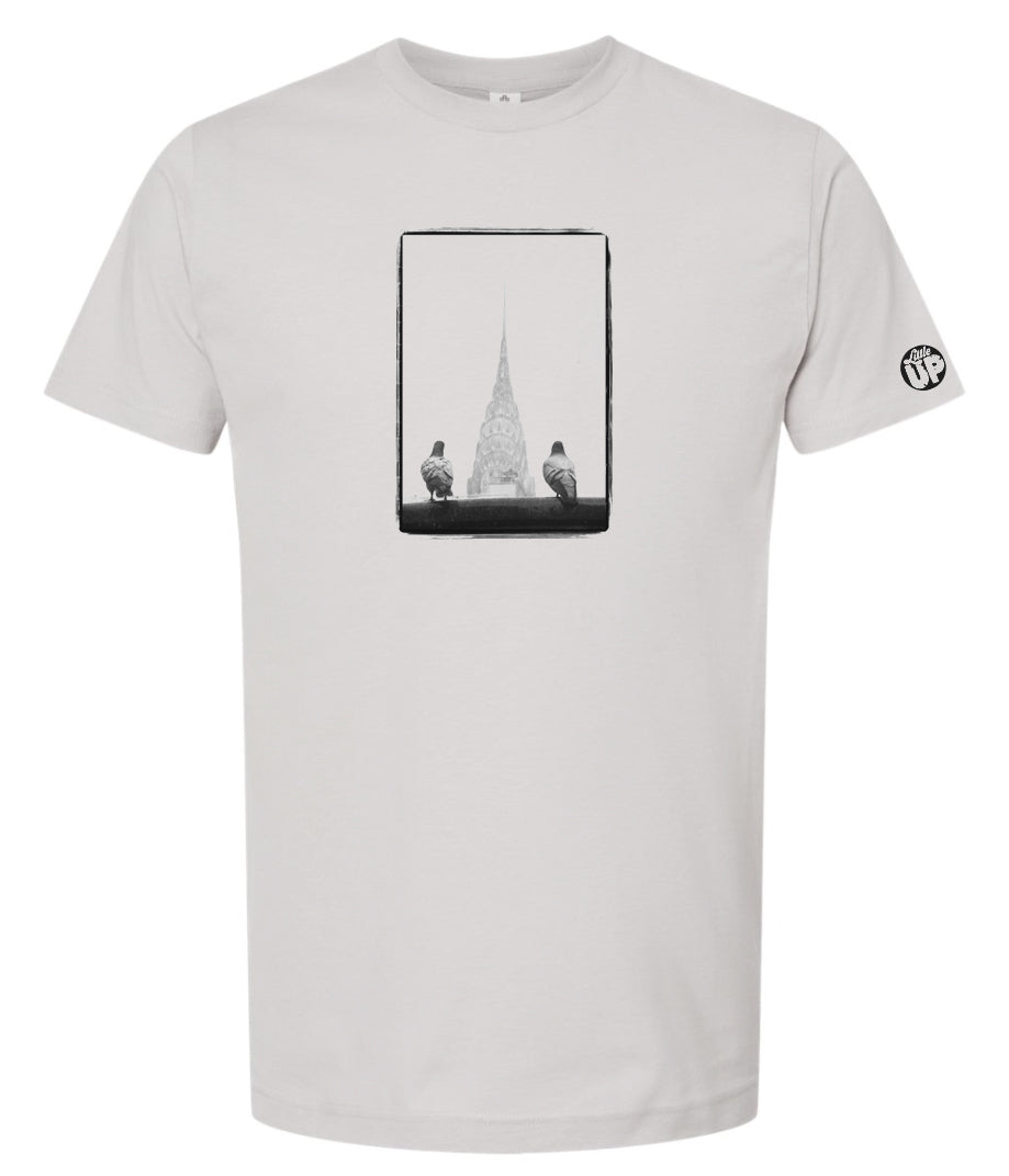 black and white photo of two pigeons in the foreground and the Chrysler Building in the background between the pigeons, on gray t-shirt