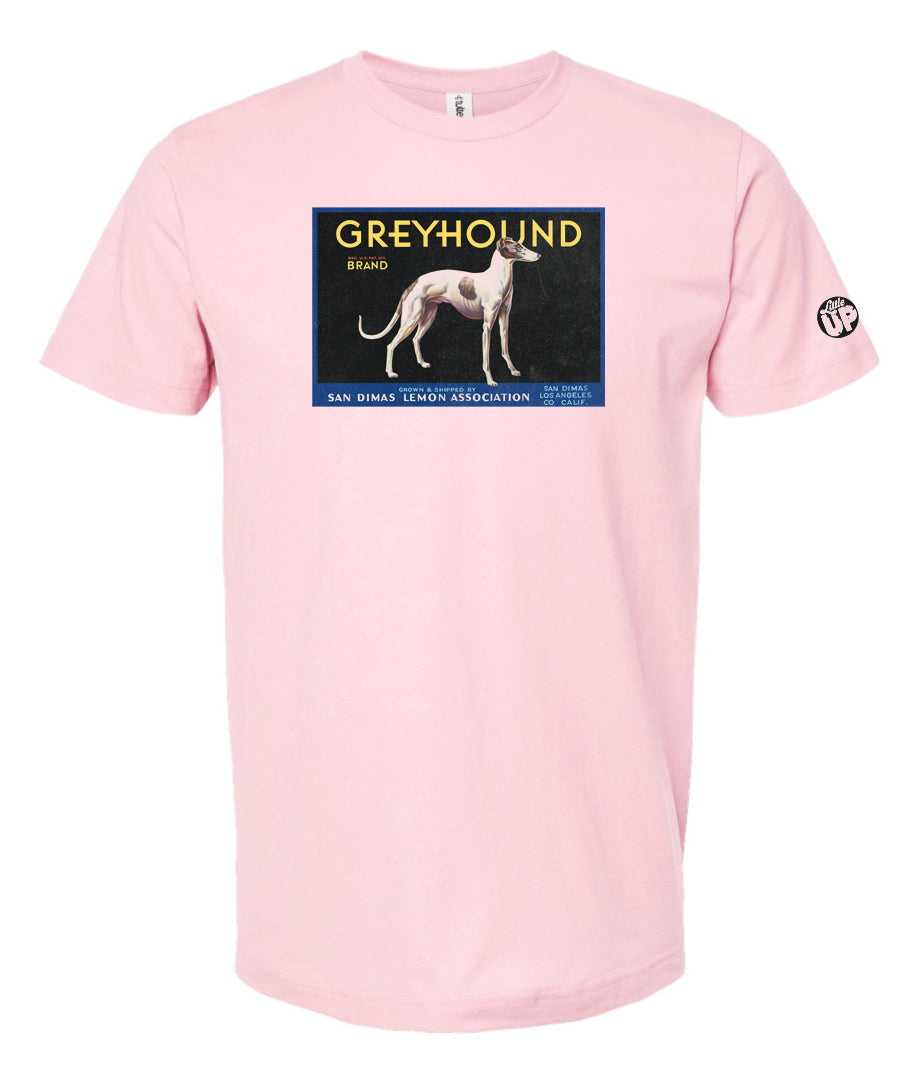 vintage packaging with illustration of white greyhound with a few large brown spots, "GREYHOUND" is the headline, printed on pink t-shirt