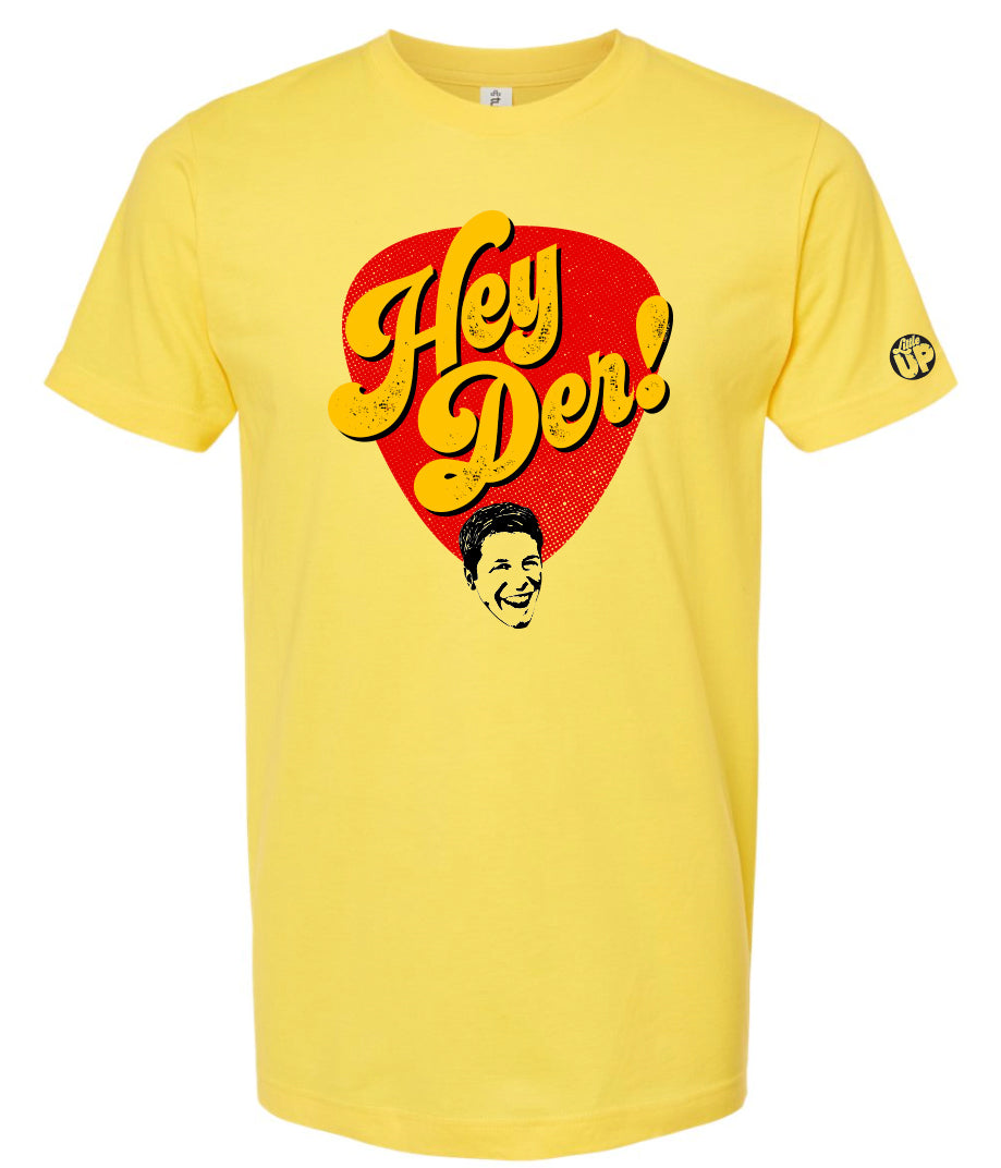 "HEY DER!" large in yellow 70s style script font in red teardrop shape with young man with big smile at the bottom on yellow t-shirt