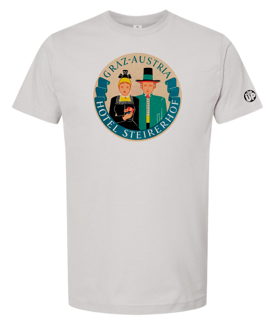 vintage round illustration of old hotel in Austria, colors include blue, orange, teal, yellow and black, printed on light gray t-shirt on white background