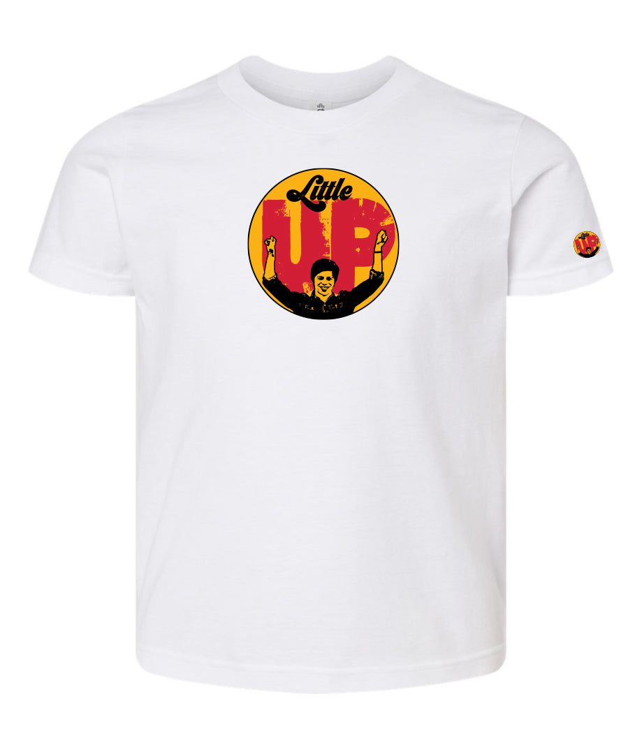 large circle with "Little" at the top in 70s script, "UP" large in red textured sans serif, illustration of young man smiling with arms raised illustration in black at the bottom, on white youth t-shirt