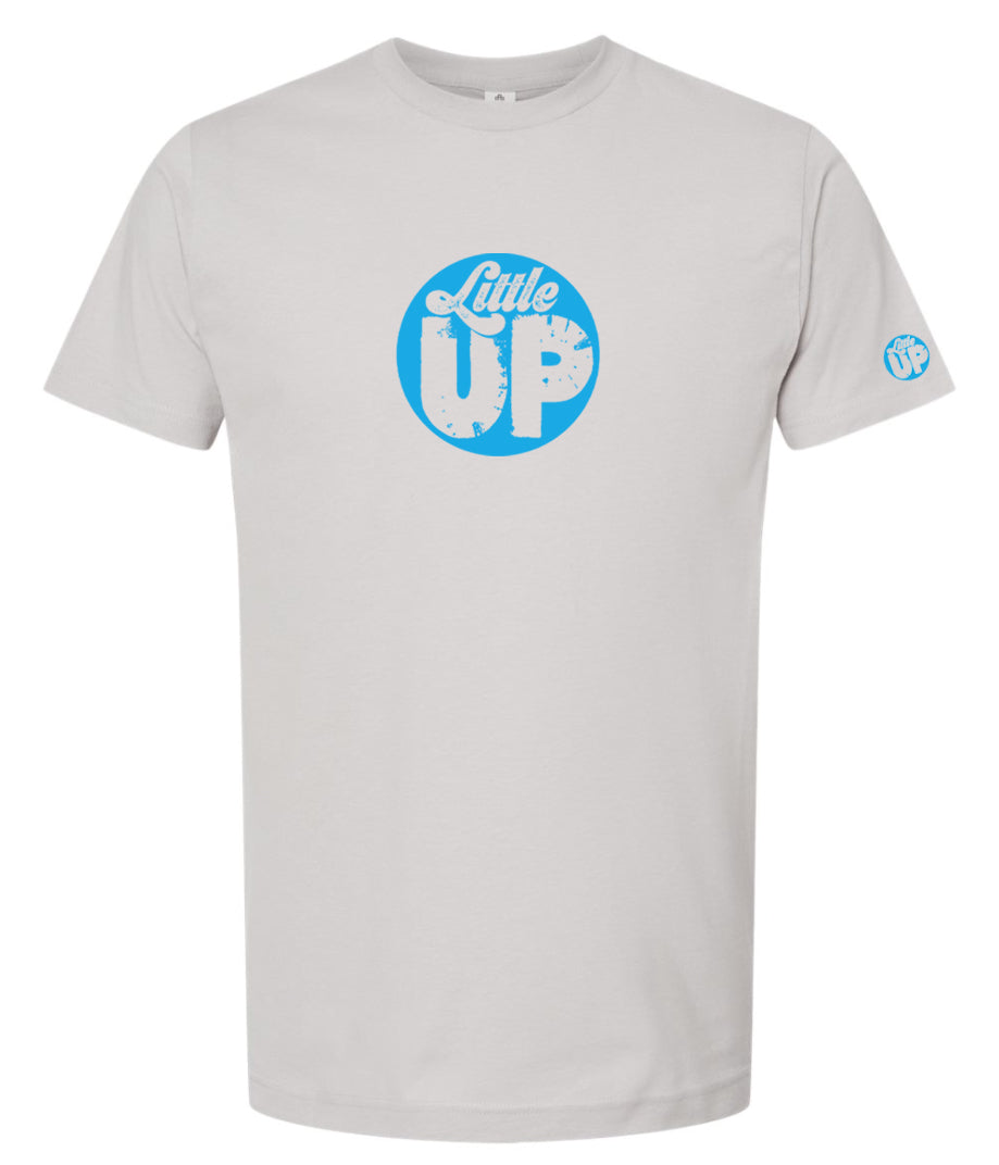 light blue circle logo with "Little" in the top third in textured seventies script and "UP" on the bottom ⅔ in modern sans serif textured font on light gray t-shirt on white studio background