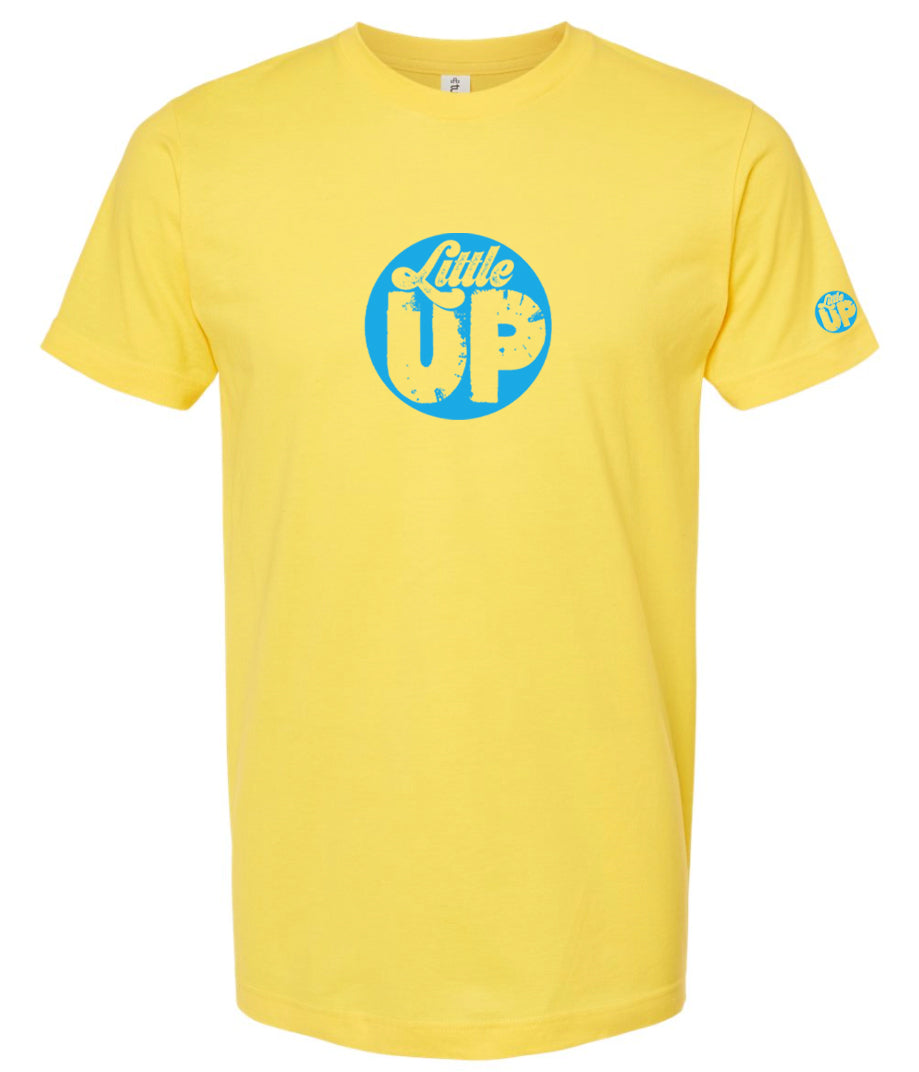 light blue circle logo with "Little" in the top third in textured seventies script and "UP" on the bottom ⅔ in modern sans serif textured font on yellow t-shirt on white studio background