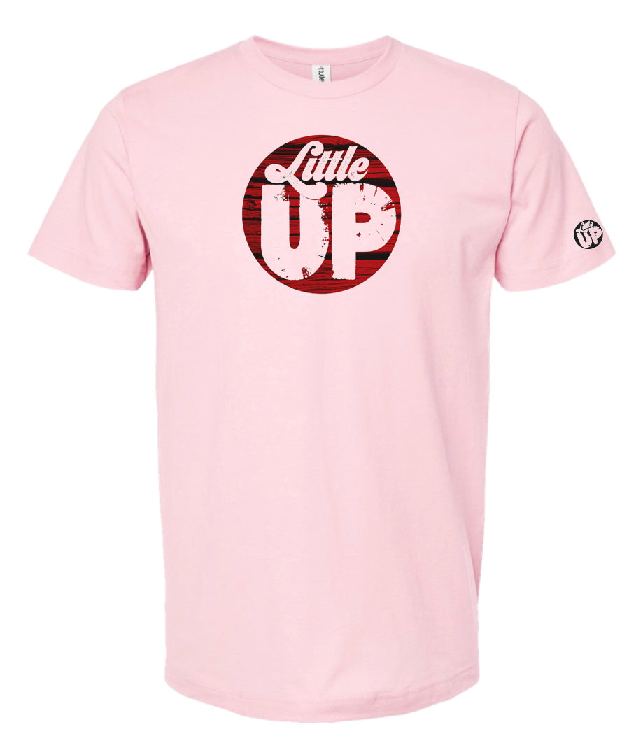 round logo with red wood background and "Little" in textured seventies script and "UP" big in sans serif textured font on pink t-shirt on white background